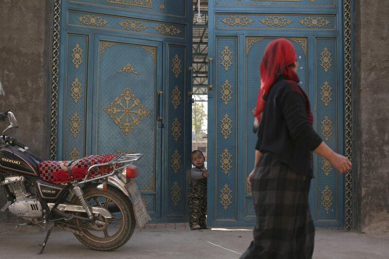 An Uighur woman walks in a residential area in turpan, Xinjiang. China's claims that it is fighting an Islamist insurgency in energy-rich Xinjiang - a vast area of deserts, mountains and forests - are not new. Michael Martina / Reuters



