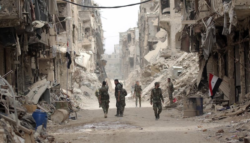 epaselect epa06755964 Syrian soldiers patrol at the Yarmouk Camp district in south Damascus, Syria, 22 May 2018. Media reports state the Syrian government of Bashar al-Assad on 21 May recaptured the last area of Damascus under opposition control and took full control of the capital for the first time since the outbreak of the civil war in 2011, after groups of Islamic State (IS) fighters holed up in an area of south Damascus, including the Palestinian refugee camp Yarmouk, were bussed out.  EPA/YOUSSEF BADAWI