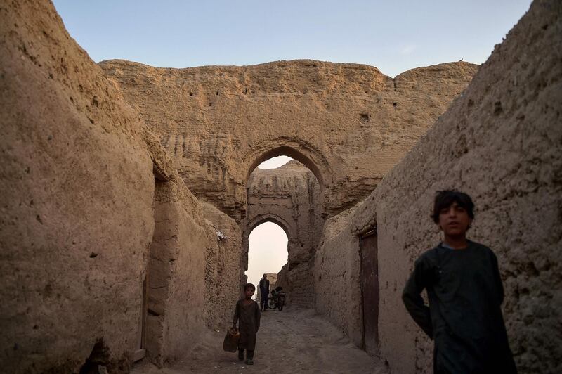 Internally displaced Afghan children walk among ruins of a palace, where they live with their families, at the historic site of Qal-e-Kohna, in Lashkar Gah, the capital of Helmand Province. AFP