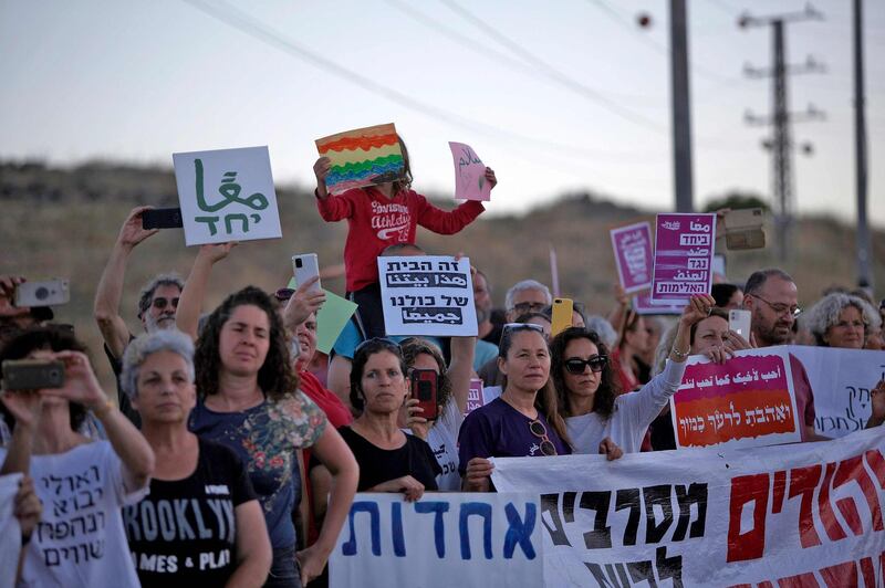 Demonstrators hold up signs as they gather for a demonstration for coexistence between Jews and Arabs in the town of Rosh Pinna in northern Israel on May 13, 2021.  / AFP / JALAA MAREY
