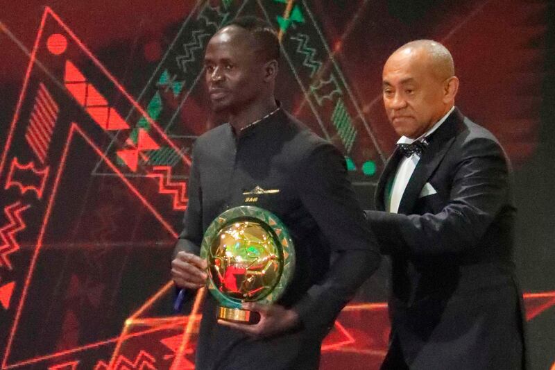 Senegal winger Sadio Mane (L) carries the Player of the Year award as he is escorted off stage by Ahmad Ahmad, President of the Confederation of African Football. AFP