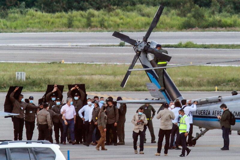Colombia's President Ivan Duque walks surrounded by bodyguards close to the presidential helicopter at the tarmac of the Camilo Daza International Airport after it was hit by gunfire in Cucuta, Colombia. AFP