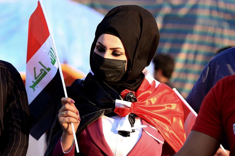 A woman holds a flag as anti-government protesters gather near Basra provincial council building during ongoing protests in Basra, Iraq. AP Photo