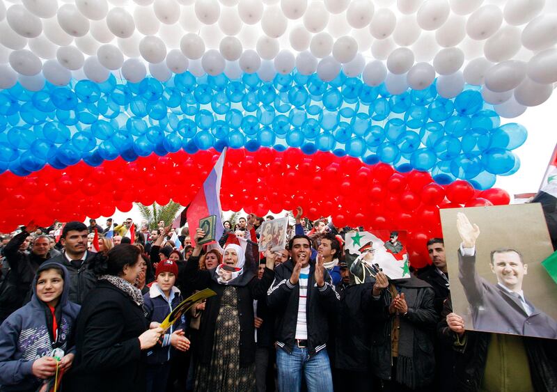 Pro-Syrian regime protesters gather under a huge Russian flag made from balloons as they cheer a convoy believed to be transporting Russian Foreign Minister Sergey Lavrov in Damascus, Syria, Tuesday, Feb. 7, 2012. Thousands of Syrians waving Russian flags cheered Russia's foreign minister as he arrived in Damascus Tuesday for talks with embattled President Bashar Assad on the country's escalating violence, as activists reported a fourth day of shelling in Homs and worsening humanitarian conditions. (AP Photo/Muzaffar Salman) *** Local Caption ***  Mideast Syria.JPEG-07d40.jpg