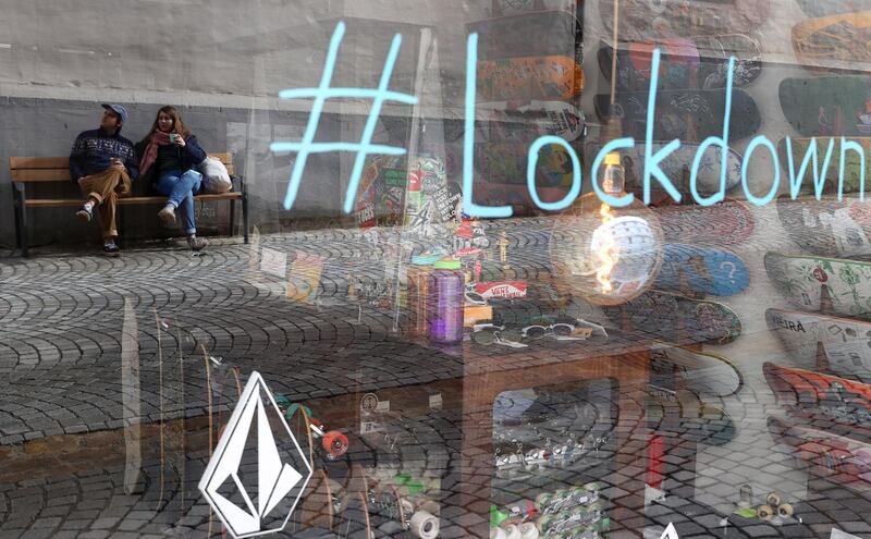 People are reflected in a shop window enjoying some sun in Tuebingen, Germany. Reuters