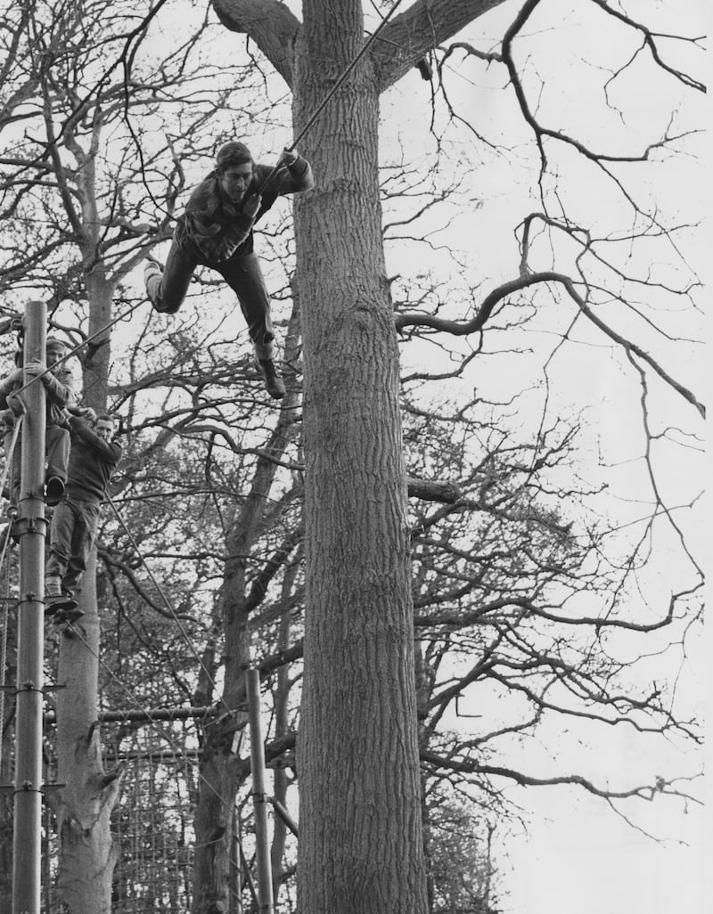The prince tackles an assault course at the Royal Marines Training Centre in Lympstone, Devon, and achieves a first-class pass, in 1975