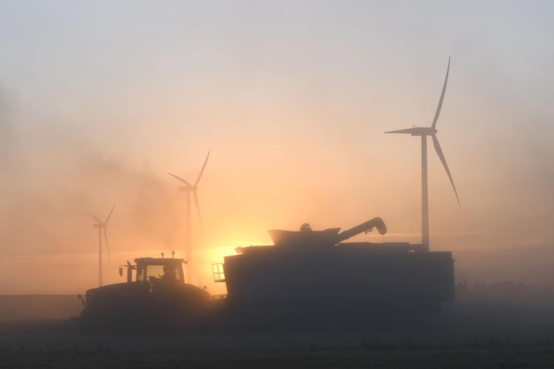 (FILES) This file photo taken on July 16, 2017 shows a French farmeras he  harvests a wheat field with a combine harvester, next to wind turbines, on a wind farm in Rouvray-Saint-Florentin, central France.
Climate change will have a negative effect on key crops such as wheat, rice, and maize, according to a major scientific report out on august 15, 2017 that reviewed 70 prior studies on global warming and agriculture. Experts analyzed previous research that used a variety of methods, from simulating how crops will react to temperature changes at the global and local scale, to statistical models based on historical weather and yield data, to artificial field warming experiments. 
 / AFP PHOTO / JEAN-FRANCOIS MONIER