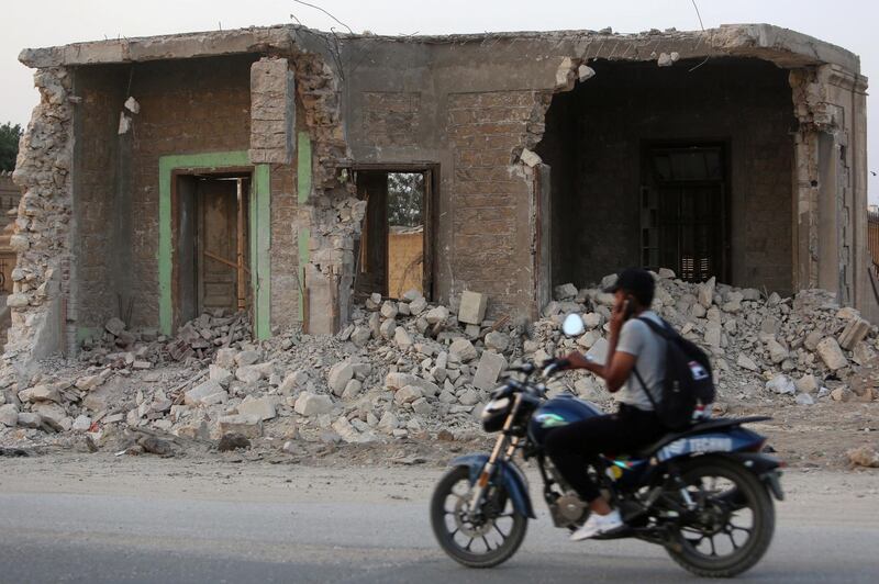 A boy riding a motorbike passes in front of the destroyed graves in Cairo, Egypt. Reuters