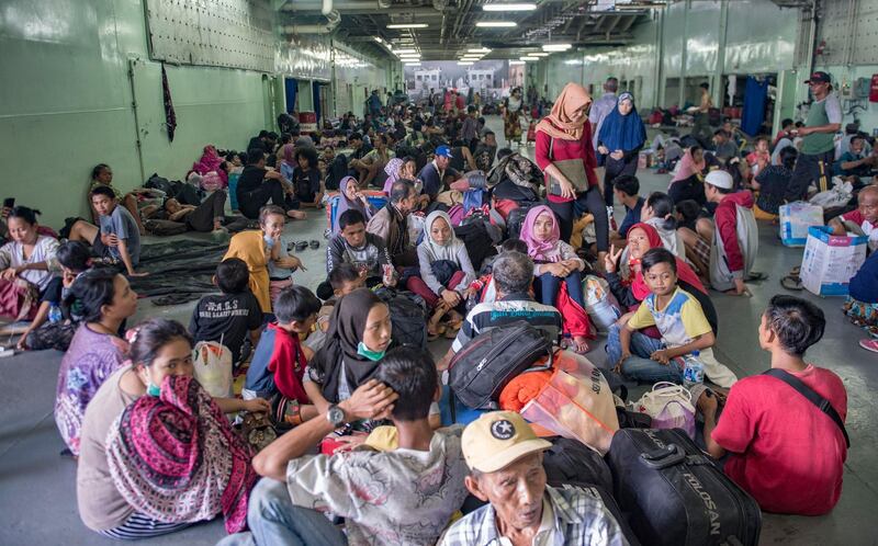 People sit together on board the Indonesian Navy warship KRI Makassar (590) as they prepare to be evacuated from Palu. AFP