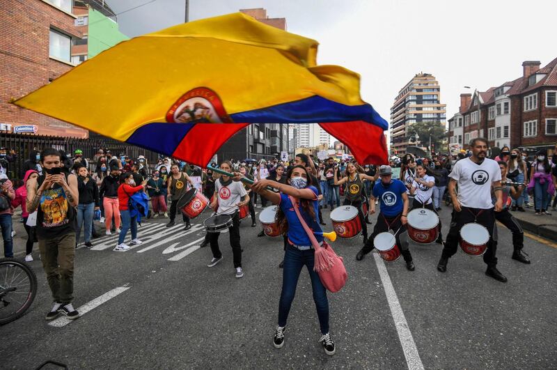 TOPSHOT - A woman waves a Colombian national flag during a protest against a tax reform proposed by Colombian President Ivan Duque's government in Bogota, on May 4, 2021.  The international community on Tuesday decried what the UN described as an 'excessive use of force' by security officers in Colombia after official data showed 19 people were killed and 846 injured during days of anti-government protests.  / AFP / Juan BARRETO
