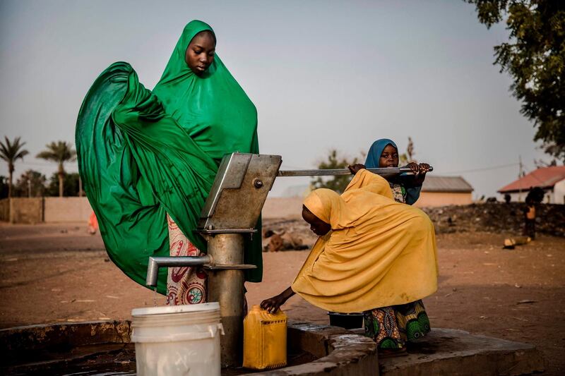 Camp dwellers pump water from a well at Malkohi refugee camp in Jimeta, Adamawa State, Nigeria on February 19, 2019, four days ahead of the country's General elections set for February 23 after a last-minute rescheduling. Malkohi is a camp for internal displaced who fled their homes as Boko Haram insurgents advanced across north-eastern Nigeria. From their homes on the outskirts of Yola, capital of presidential candidate Atiku Abubakar's home state Adamawa, Malkohi residents say they feel forgotten. / AFP / Luis TATO
