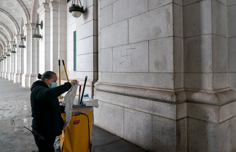 A worker prepares to cover swastikas drawn on the front of Union Station. AP