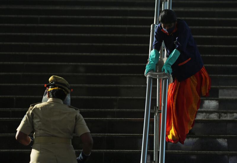 A member of the Bengaluru Metro Rail Corporation Limited ground staff cleans at the city metro station in Bangalore, India.  EPA