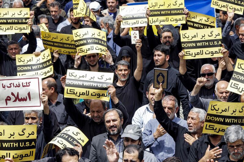 Demonstrators in Tehran march with signs denouncing the US and Israel as they condemn the burning of the Quran. AFP
