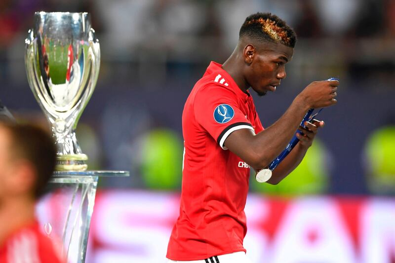 Manchester United's Paul Pogba removes his medal after losing the UEFA Super Cup. Dimitar Dilkoff / AFP