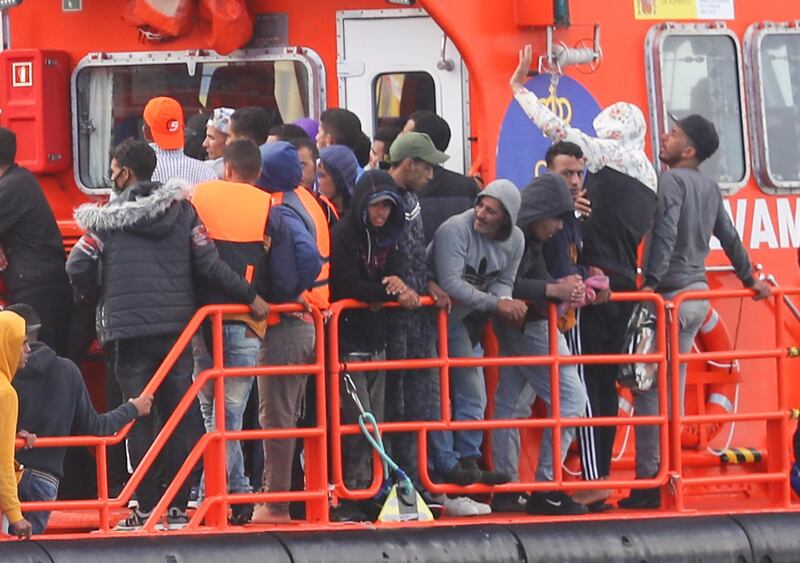 epa08808154 Some of the over 100 migrants arrive at Arguineguin's port after being rescued by Spanish Salvamento Maritimo as they sailed around the southern part of the island on board of several small dugouts, in Gran Canaria, Canary islands, Spain, 07 November 2020.  EPA/Patricia Urquijo A.