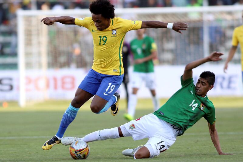 Brazil midfielder Willian is slide-tackled by Raul Castro of Bolivia. Daniel Rodrigo / Reuters