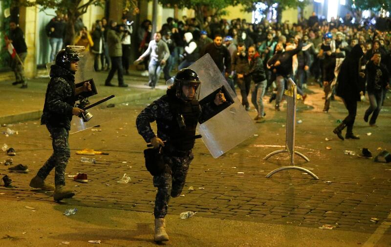 Riot police run for cover during anti-government protests in Beirut. Reuters