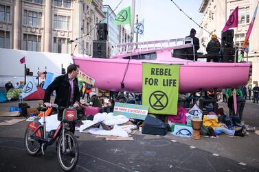 A man pushes his bicycle past the Extinction Rebellion boat in the centre of Oxford Cricus in London. Now in the third day of action, the environmental campaign group has blocked a number of key junctions in central London, in a bid to highlight the ongoing ecological crisis. Getty Images