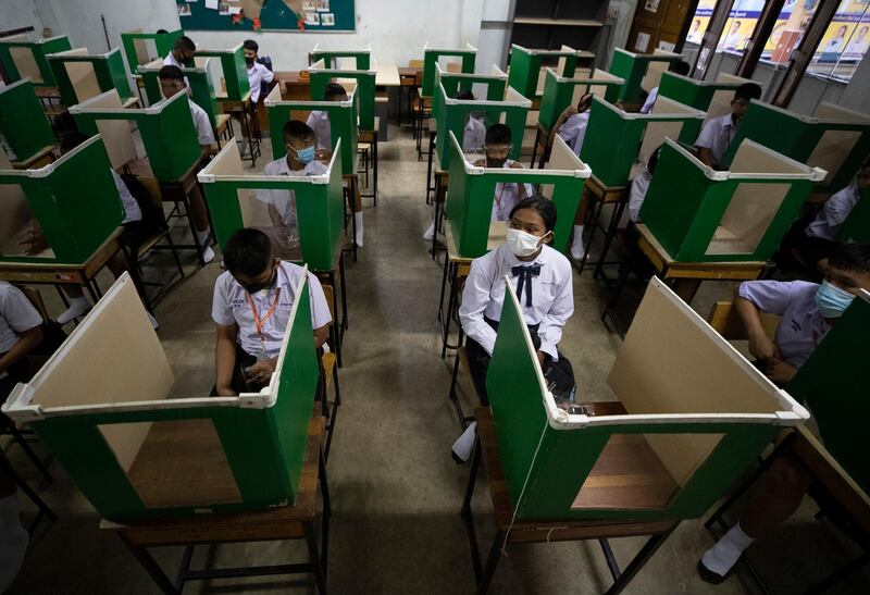 Students in a protective gear are seated at partitioned desks at the Samkhok School in Pathum Thani, outside Bangkok. AP Photo