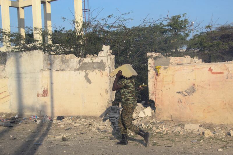 An African Union soldier carries a vehicle component after a suicide bombing in Mogadishu, Somalia, last year. AFP