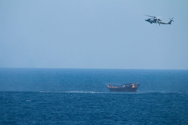 A US Navy Seahawk helicopter flies over a stateless dhow later found to be carrying a hidden arms shipment in the Arabian Sea, in  May 2021.  AP