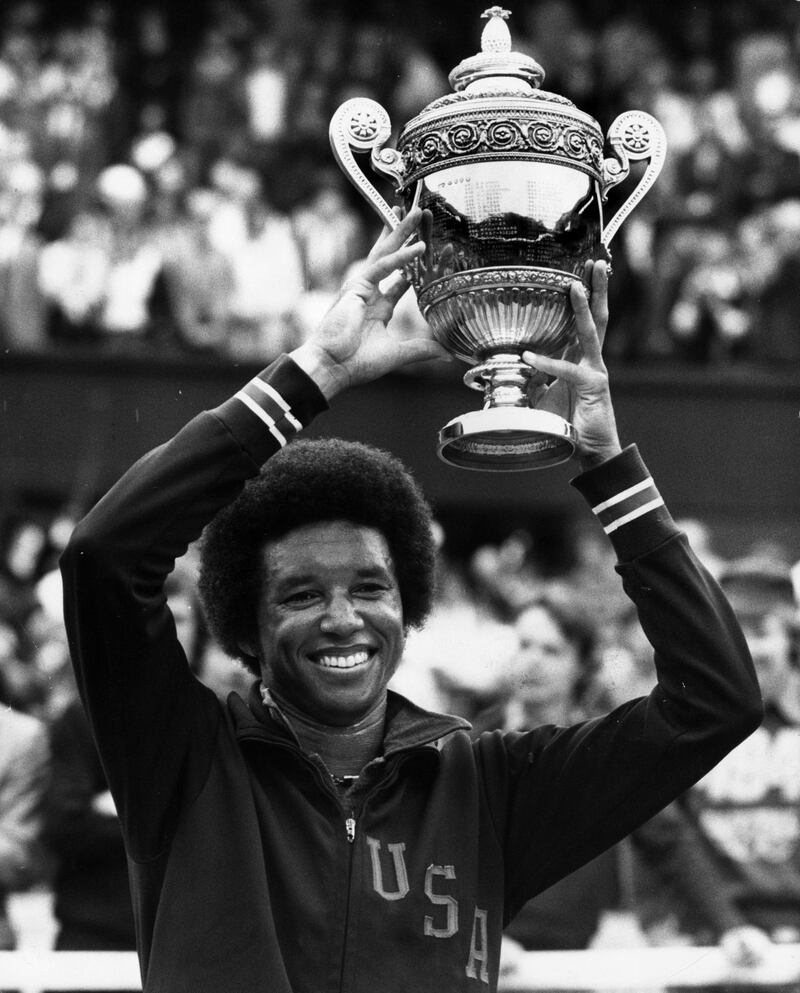 4th July 1975:  American tennis player Arthur Ashe (1943 - 1993) holding aloft the trophy after beating compatriot Jimmy Connors in the men's singles finals at the Wimbledon Lawn Tennis Championships.  (Photo by David Ashdown/Keystone/Getty Images)