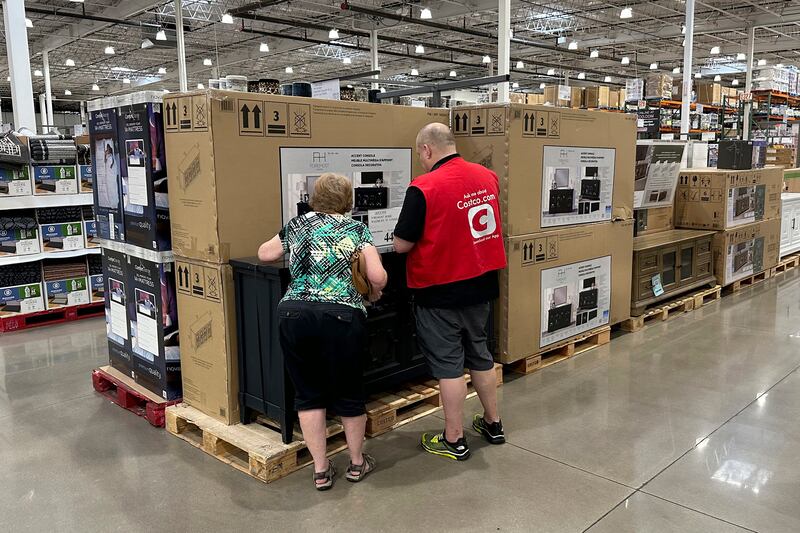 A sales associate helps a shopper at a Costco. Inflation in the US edged up in July after 12 straight months of declines. AP
