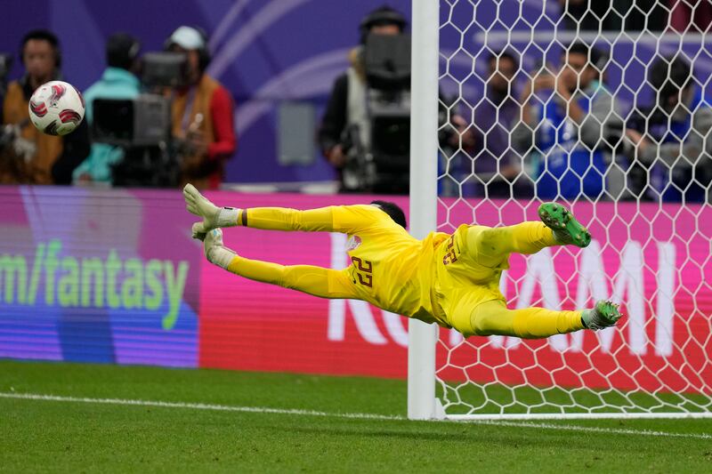 Qatar's goalkeeper Meshaal Barsham dives to save a penalty by Uzbekistan's Zafarmurod Abdirakhmatov during the shoot out. AP