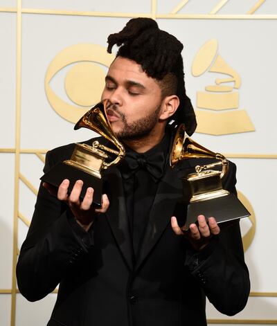 FILE - The Weeknd poses in the press room with the awards for best R&B performance for "Earned It (Fifty Shades of Grey)" and best urban contemporary album for "Beauty Behind The Madness" at the 58th annual Grammy Awards in Los Angeles on Feb. 15, 2016. The Weeknd had the No. 1 song of 2020 but â€œBlinding Lightsâ€ was not nominated for a Grammy Award. (Photo by Chris Pizzello/Invision/AP, File)