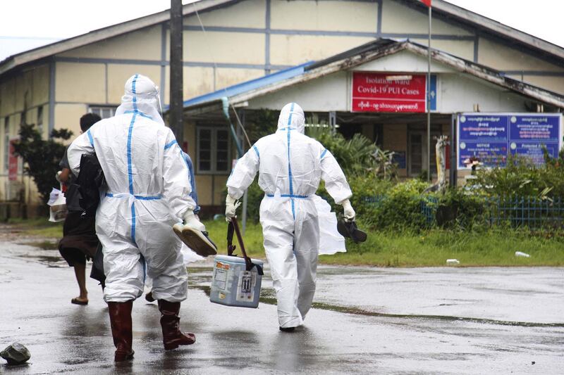 Medical workers wearing personnel PPE walk towards the isolation ward of a hospital in Sittwe, Rakhine State, western Myanmar.  EPA