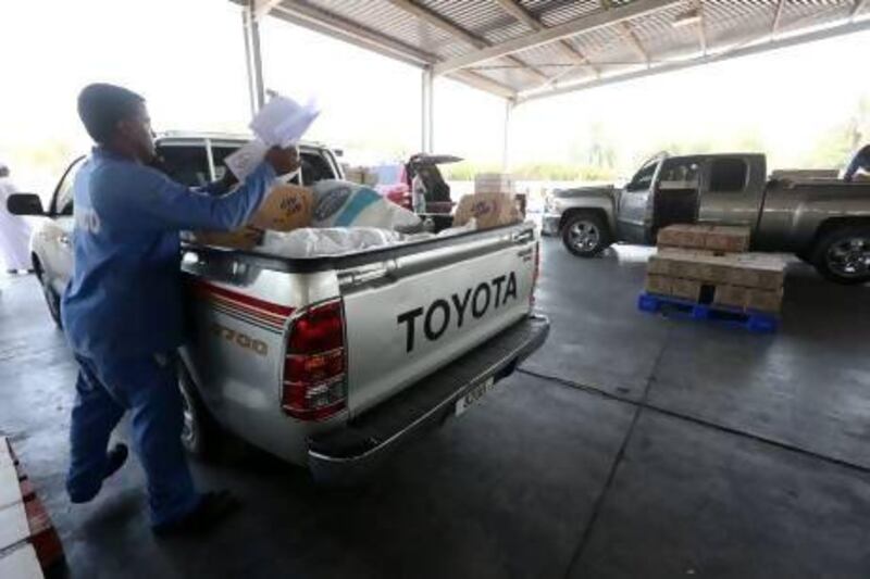 Food supplies are loaded on to a pickup truck yesterday as Emiratis queued to take advantage of Abu Dhabi Municipality’s subsidised food supplies initiative, which has been expanded from last year, as the emirate’s citizens prepare for Ramadan. Fatima Al Marzooqi / The National
