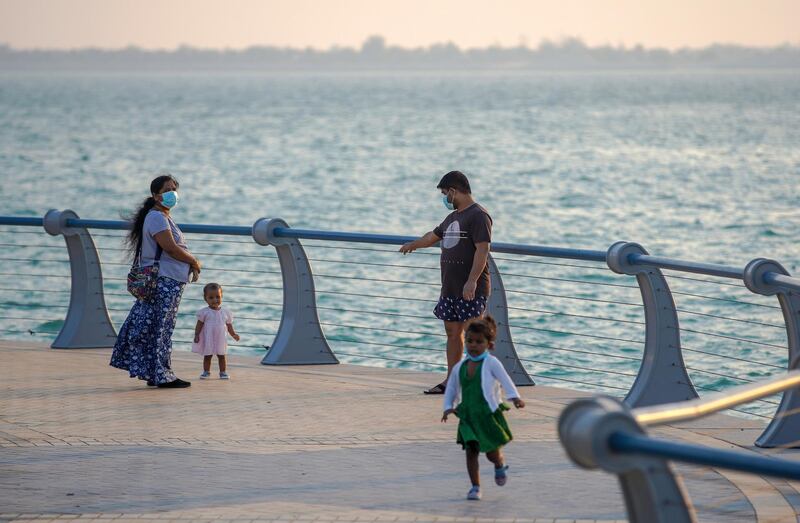 Abu Dhabi, United Arab Emirates, June 28, 2020.   
  A family walks along the Corniche as the sun sets on the Dhow Harbour.
Victor Besa  / The National
Section:  Standalone
Reporter:  none