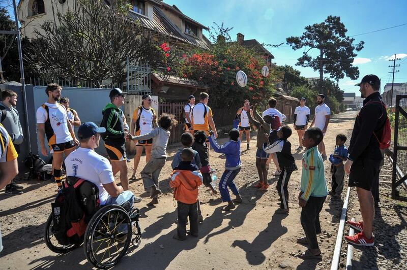 Mike Ballard passes the ball to children, who had followed the Conquistadors team from their hotel to the stadium for their training session in Antananarivo. 1 July 2016. Photo: Rafalia Henitsoa for The National