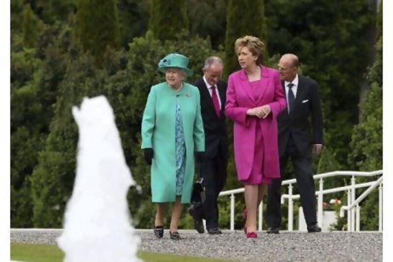 Britain's Queen Elizabeth II and the Irish president, Mary McAleese, walk together after a tree planting ceremony at the Irish President's residence in Phoenix Park, Dublin yesterday.