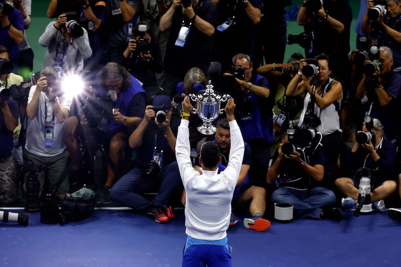 Photographers take snaps of Novak Djokovic lifting the US Open trophy. Getty