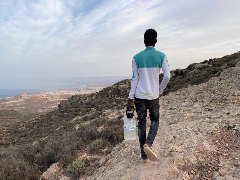 Musa (not real name), a 18-year old Malian migrant, carrying a water bottle refilled in a spring, comes back to a migrant camp in Gurugu Mountain, Morocco. EPA