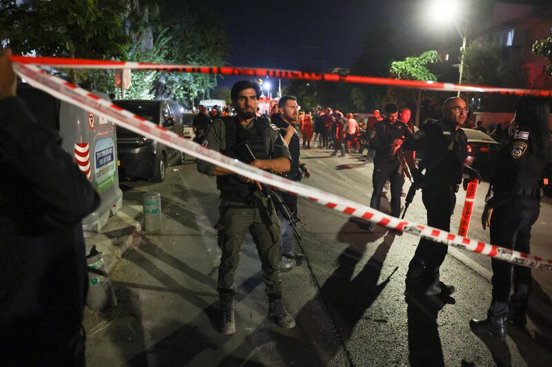 Israeli security forces gather along a cordoned-off street where an apartment building was hit by a rocket fired from Gaza, in Rishon LeZion, near Tel Aviv. AFP