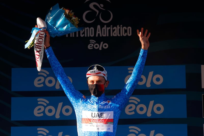 epa09072340 Slovenian rider Tadej Pogacar of UAE Team Emirates celebrates on the podium wearing the overall leader's jersey after winning the 4th stage of the Tirreno Adriatico 2021, starting from Terni and arriving after 148 km in Prati di Tivo, Prati di Tivo, Italy, 13 March 2021.  EPA/LUCA BETTINI
