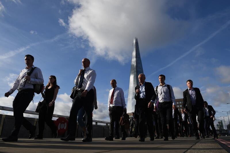 (FILES) In this file photo taken on June 05, 2017 Commuters walk across London Bridge, backdropped by The Shard, in London, after the bridge was partially re-opened following the June 3 terror attack. The number of workers on UK company payrolls slumped by a further 114,000 in July from June on fallout from the coronavirus pandemic, official data showed on August 11, 2020. A total 730,000 positions have been shed since March, when Britain went into lockdown over COVID-19, the Office for National Statistics said in a statement. / AFP / Justin TALLIS
