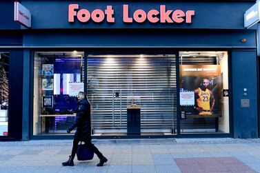 A woman walks past a closed footwear shop in Berlin on Friday. EPA 