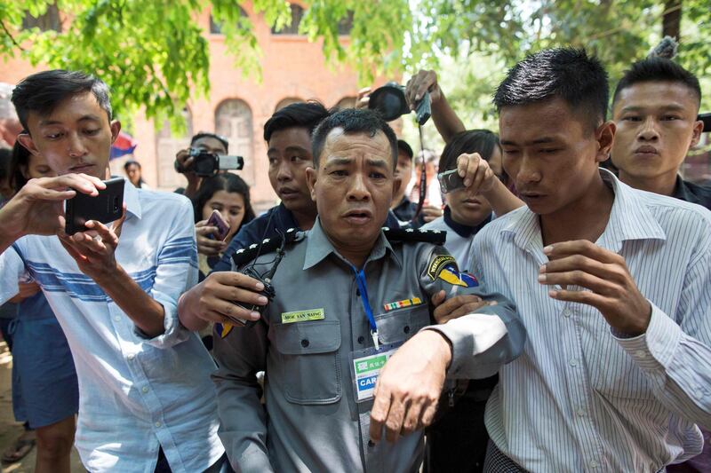 (FILES) In this file photo taken on April 20, 2018 Myanmar deputy police major Moe Yan Naing (C) leaves the court following the ongoing trial of two detained journalists in Yangon.
A Myanmar policeman who shocked observers by testifying against his force when he described their effort to "entrap" two Reuters journalists has been sentenced to prison, a police spokesman said April 30, 2018. / AFP PHOTO / Sai Aung MAIN