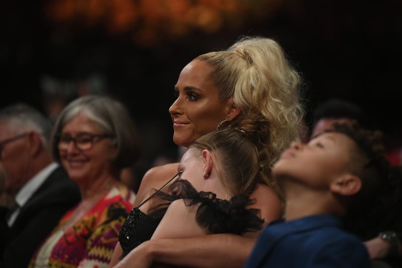 The Undertaker's wife and former WWE wrestler Michelle McCool and their daughter watch from the audience.