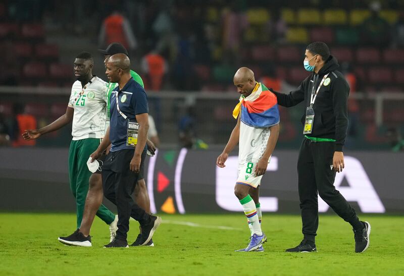 Comoros' Fouad Bachirou, second from right, leaves the field with team staff members at the end of the match. AP Photo