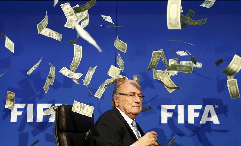 Outgoing Fifa president Sepp Blatter appears frazzled on Monday after British comedian Lee Nelson, unseen, throws banknotes at Blatter just before the start of a news conference for the Extraordinary Fifa Executive Committee meeting in Zurich, Switzerland. Arnd Wiegmann / Reuters

