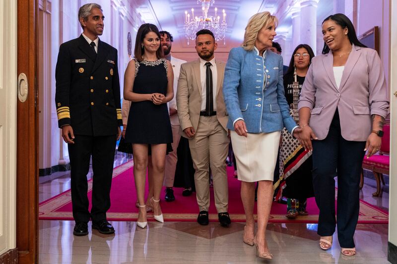 US first lady Jill Biden holds hands with youth mental health advocate Ayanna Kelly, right, as they arrive at the White House, with (from left), Surgeon General Dr Vivek Murthy and actress Selena Gomez. AP Photo