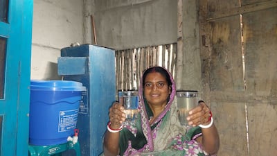A woman shows the quality of water after a biosand filter has removed contaminants. Photo: Ledars

