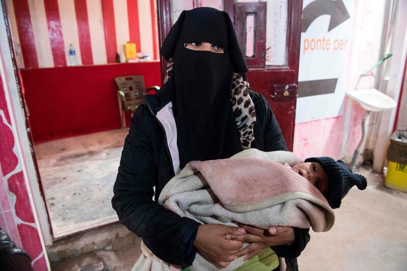 A Syrian woman holding a child waits at a makeshift clinic at the camp for the displaced in al-Hasakeh governorate in northeastern Syria. AFP