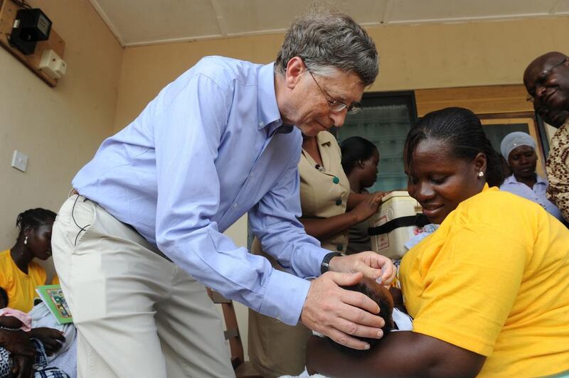 Microsoft co-founder Bill Gates, one of the world’s richest men and highest profile aid donors, gives to a child a rotavirus vaccine in Awutu Senya, Ghana. Puis Utomi Ekpei / AFP