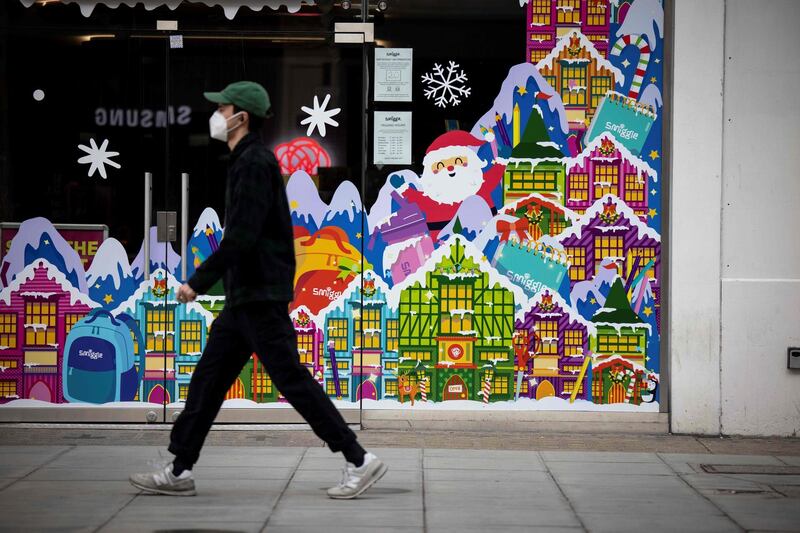 A pedestrian walks past a Christmas-themed window display in central London. AFP